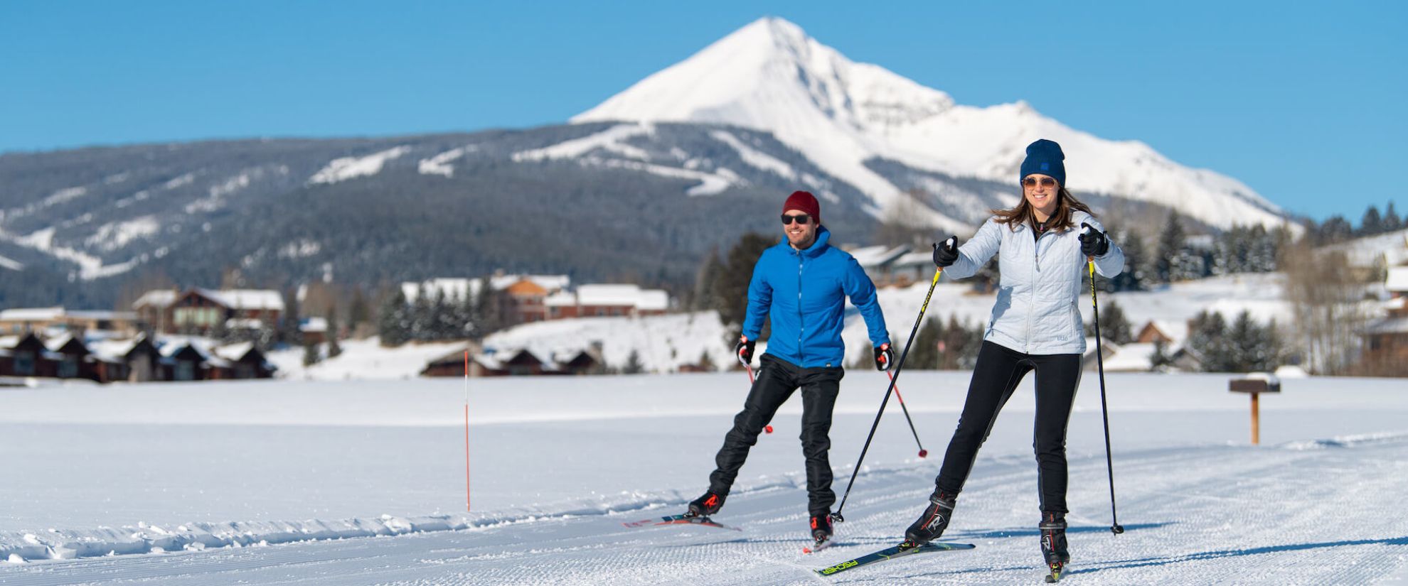 Two nordic skiers with Lone Mountain in background