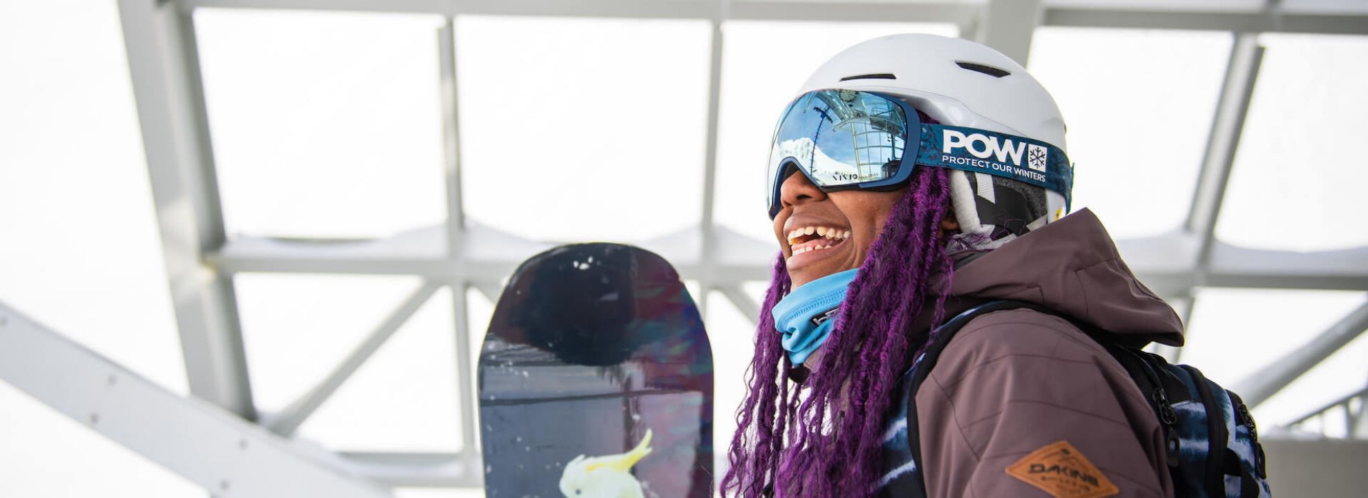 Woman Smiling while holding snowboard